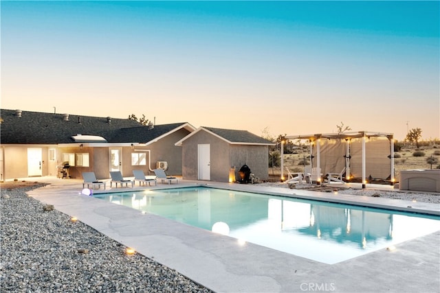 pool at dusk featuring a pergola and a patio