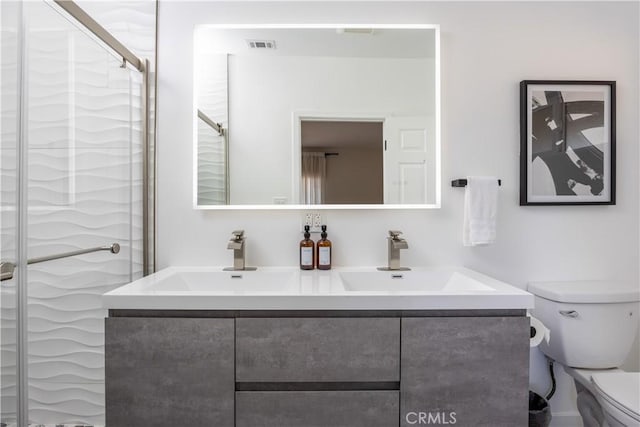 bathroom with toilet, a shower with door, and vanity