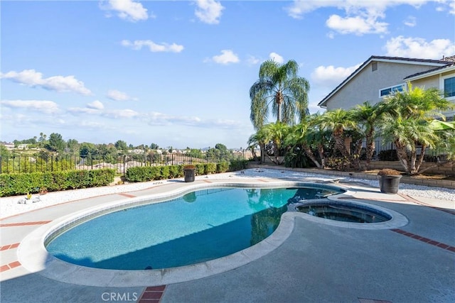 view of swimming pool featuring a patio area and an in ground hot tub