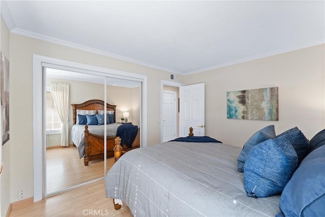 bedroom featuring hardwood / wood-style flooring, a closet, and ornamental molding