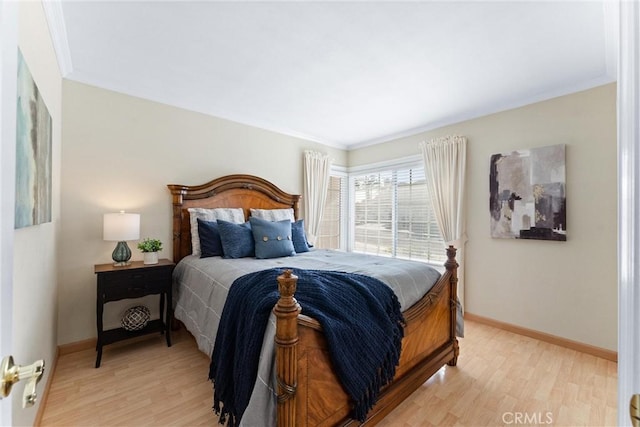 bedroom with light hardwood / wood-style floors and crown molding