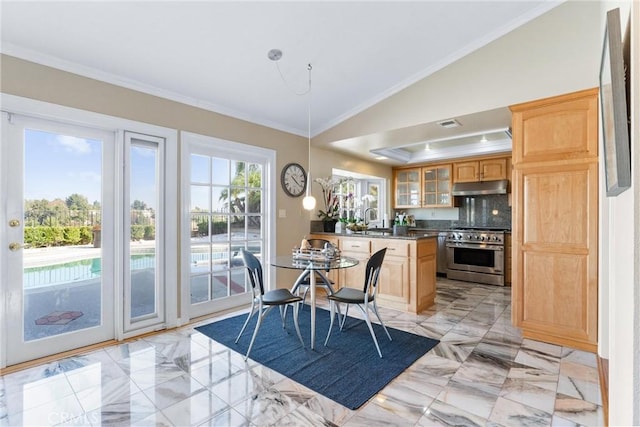 dining room featuring sink, crown molding, and lofted ceiling