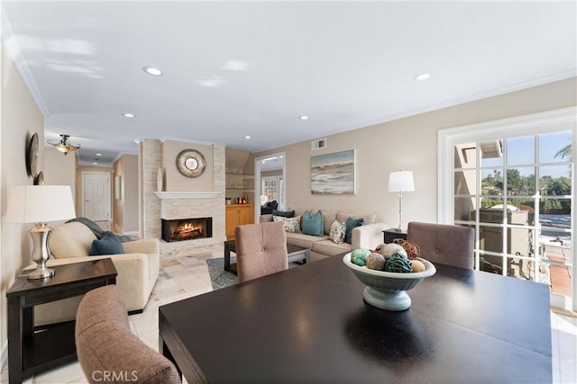 dining area with ornamental molding and a fireplace