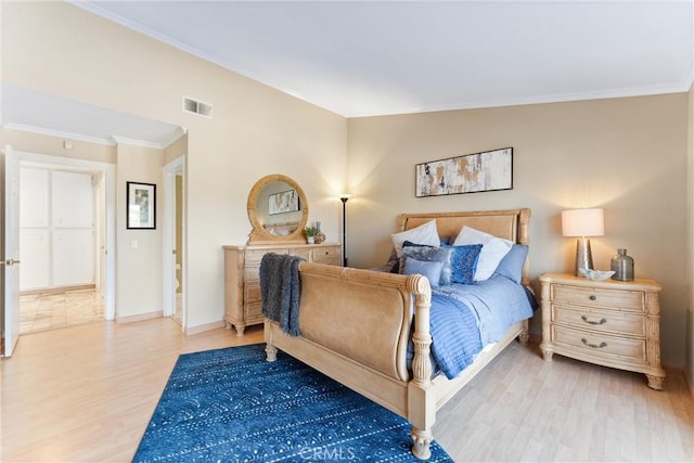 bedroom with crown molding and light hardwood / wood-style flooring