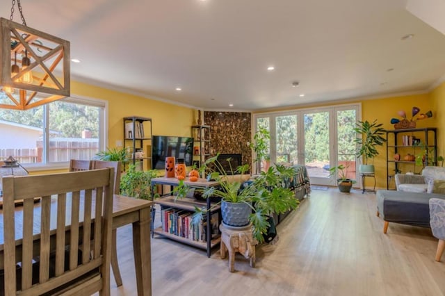 living room featuring light hardwood / wood-style flooring, crown molding, and a premium fireplace