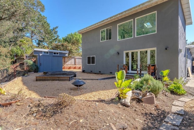 rear view of property with a storage shed