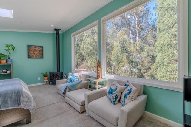 bedroom featuring light carpet, a skylight, crown molding, and a wood stove