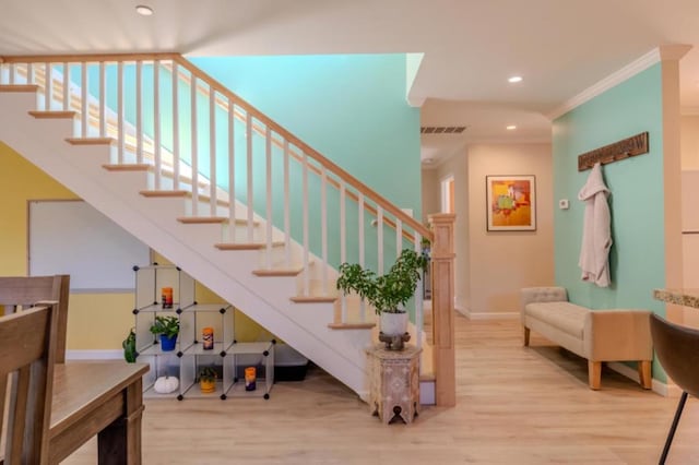 stairs with hardwood / wood-style flooring and crown molding