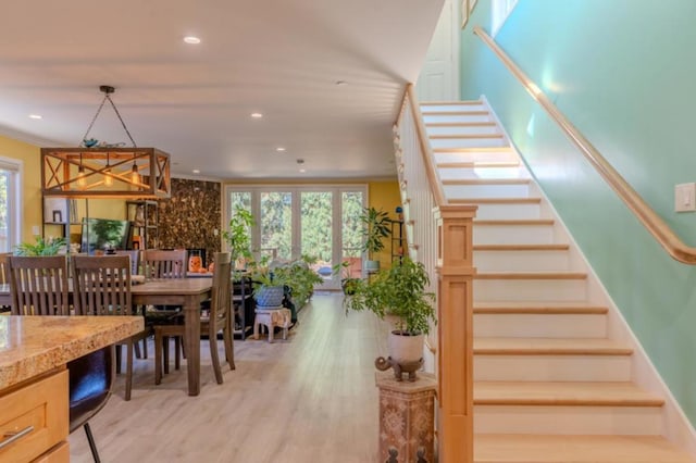 staircase with ornamental molding and hardwood / wood-style flooring