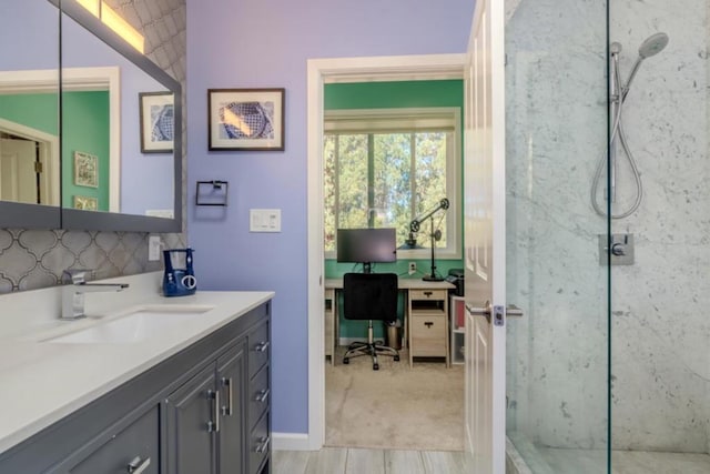 bathroom featuring wood-type flooring, tiled shower, and vanity