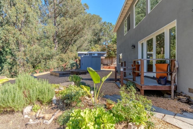 view of yard featuring a deck and a shed