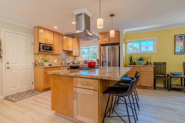 kitchen with light hardwood / wood-style floors, island range hood, appliances with stainless steel finishes, decorative light fixtures, and a center island