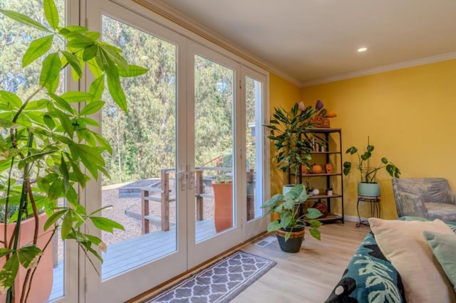 doorway featuring plenty of natural light, ornamental molding, french doors, and light wood-type flooring