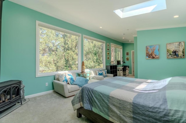 carpeted bedroom featuring a skylight and a wood stove