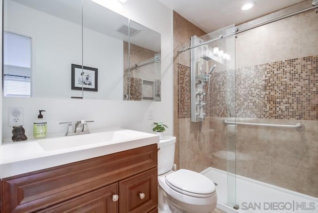 bathroom featuring walk in shower, vanity, and toilet