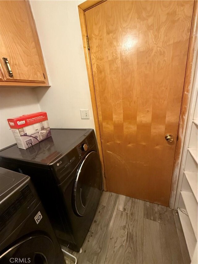 washroom featuring light hardwood / wood-style floors, cabinets, and independent washer and dryer