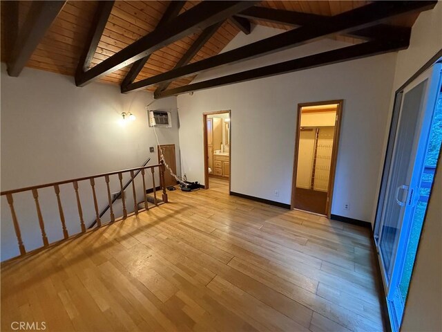 empty room with light wood-type flooring, wood ceiling, vaulted ceiling with beams, and a wall mounted air conditioner