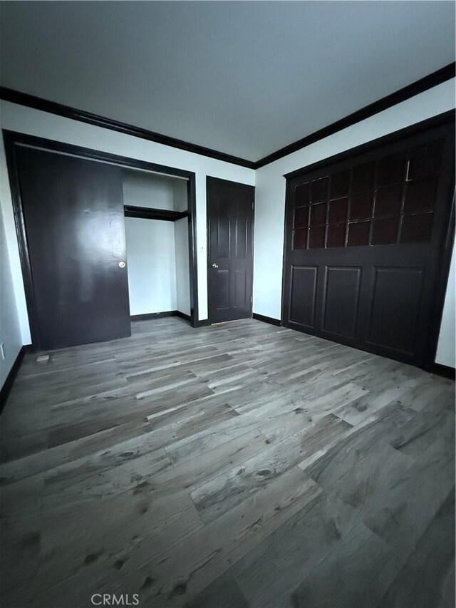 unfurnished bedroom with ornamental molding and hardwood / wood-style floors