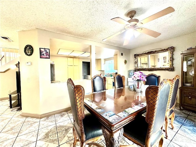 dining area featuring a textured ceiling and ceiling fan