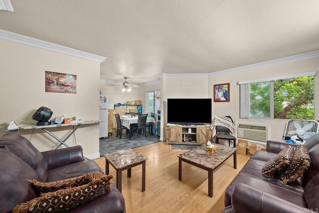 living room with an AC wall unit, a wealth of natural light, crown molding, and ceiling fan