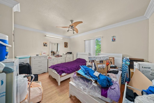 bedroom featuring ceiling fan, a textured ceiling, ornamental molding, and light wood-type flooring