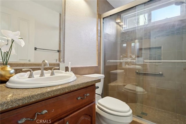 bathroom with vanity, an enclosed shower, and toilet