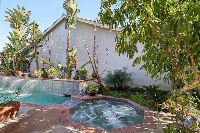 view of pool with an in ground hot tub and pool water feature