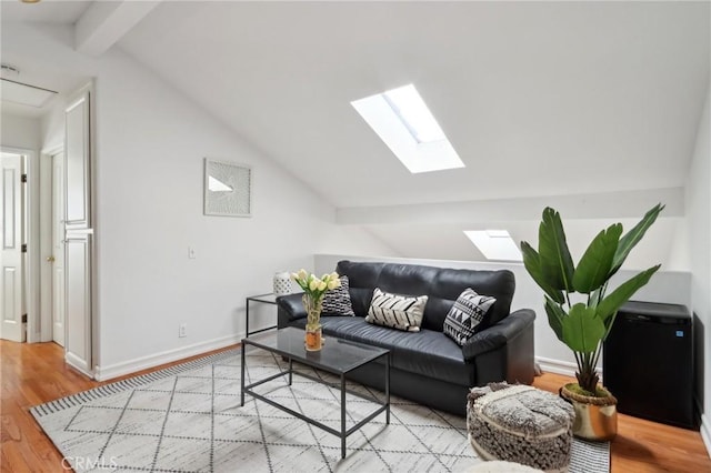 living room featuring hardwood / wood-style floors and vaulted ceiling with skylight