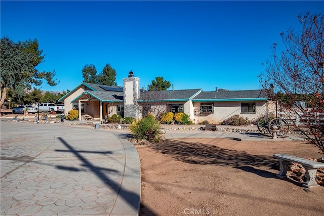 ranch-style house featuring solar panels