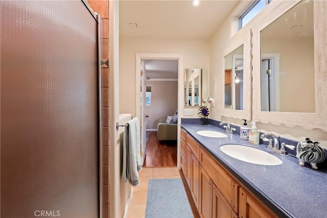 bathroom with a shower with door, vanity, and tile patterned flooring