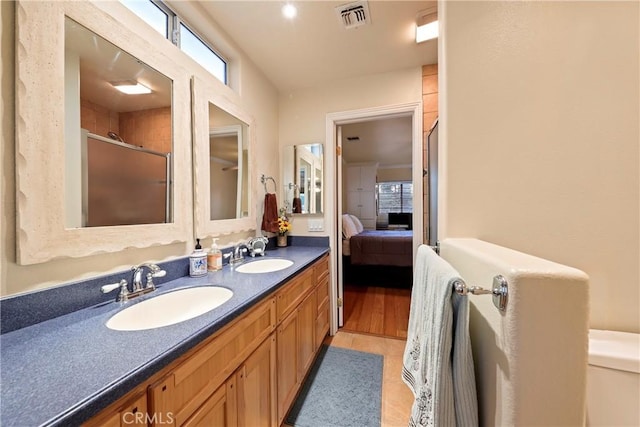 bathroom with toilet, vanity, tile patterned flooring, and a shower with shower door