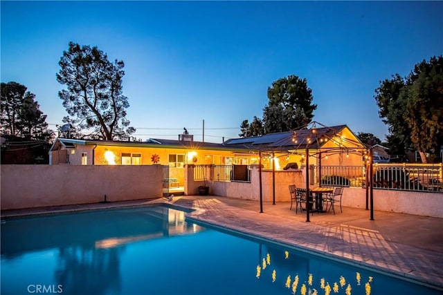 pool at dusk with a patio