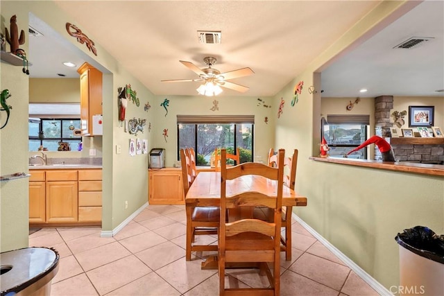 dining room featuring ceiling fan, sink, and light tile patterned flooring