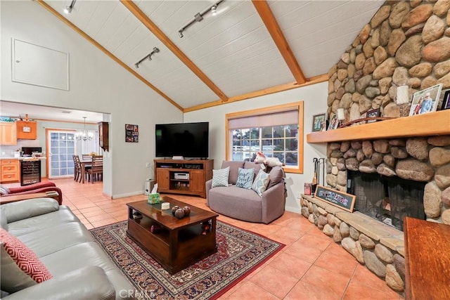 living room featuring track lighting, a fireplace, high vaulted ceiling, light tile patterned floors, and beam ceiling