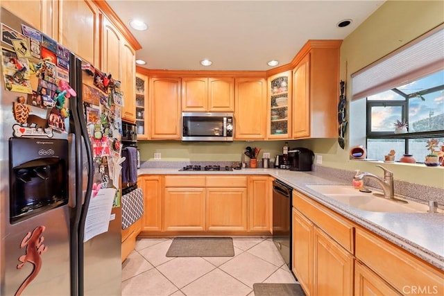 kitchen featuring light tile patterned floors, stainless steel appliances, light brown cabinets, and sink