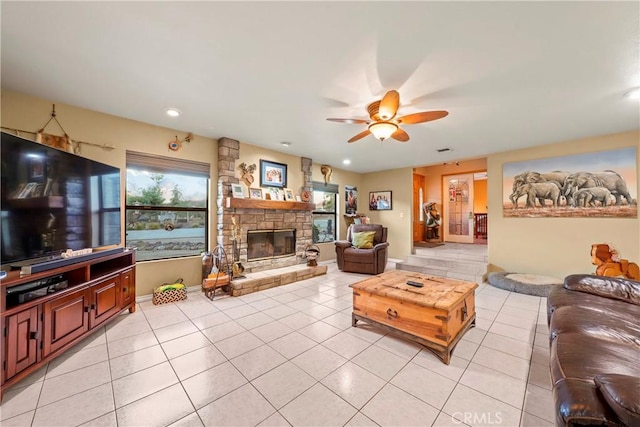 living room featuring ceiling fan, light tile patterned floors, and a fireplace