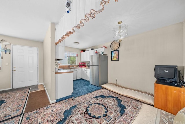 kitchen featuring white cabinets and stainless steel fridge