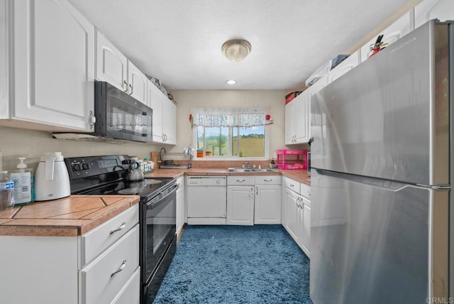 kitchen featuring sink, white cabinets, and black appliances