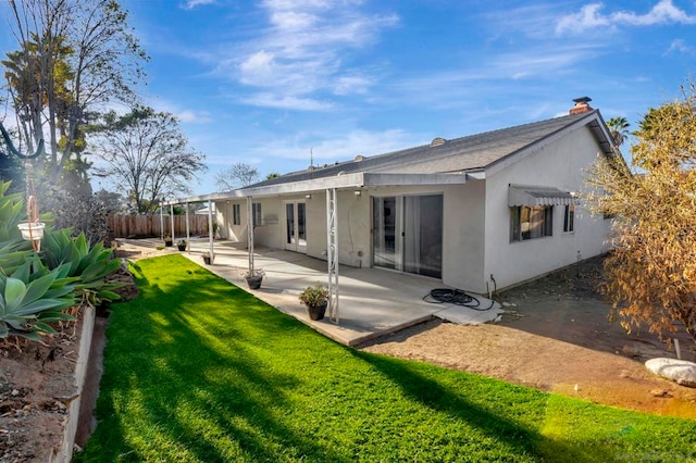 back of house with a patio area and a yard