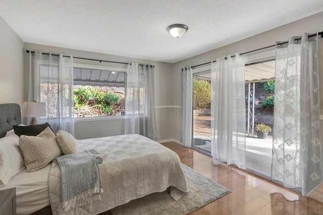 bedroom featuring access to outside and hardwood / wood-style floors