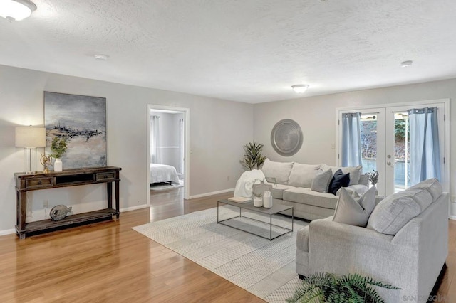 living room featuring french doors, a textured ceiling, and hardwood / wood-style floors