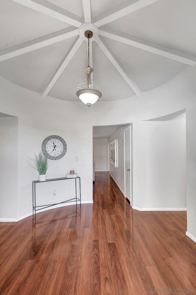 empty room featuring dark hardwood / wood-style floors and beam ceiling