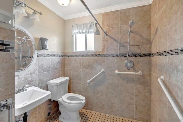 bathroom featuring toilet, tiled shower, tile walls, crown molding, and sink