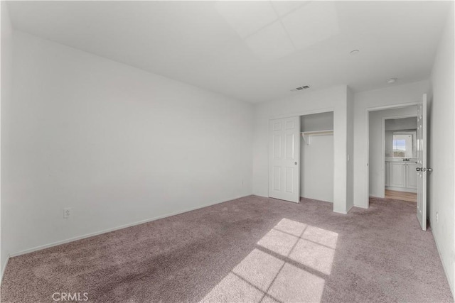 unfurnished bedroom featuring a closet and light carpet