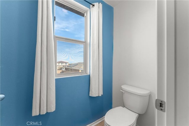 bathroom featuring plenty of natural light and toilet