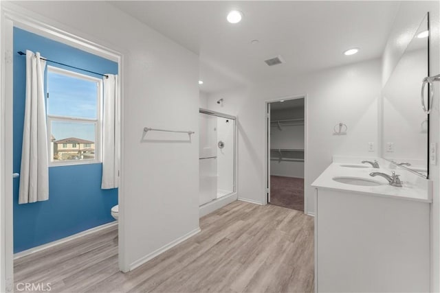 bathroom with an enclosed shower, vanity, hardwood / wood-style flooring, and toilet