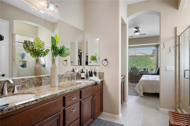 bathroom with a shower with door, vanity, ceiling fan, and tile patterned flooring