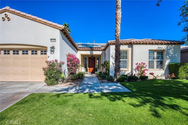 mediterranean / spanish-style home with a front lawn and solar panels