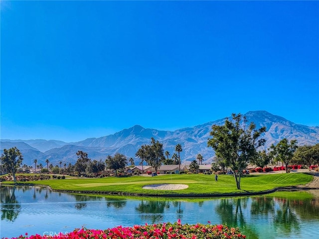 view of property's community with a water and mountain view and a lawn