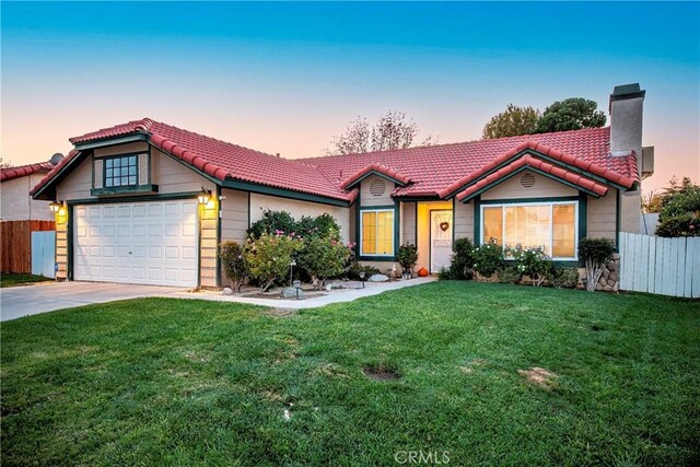 ranch-style house with a garage and a lawn